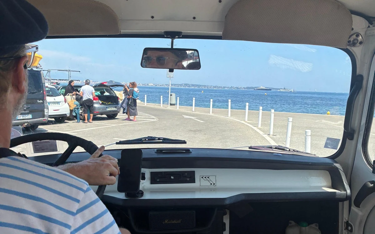 A road by the sea seen through the windscreen of a vintage bus