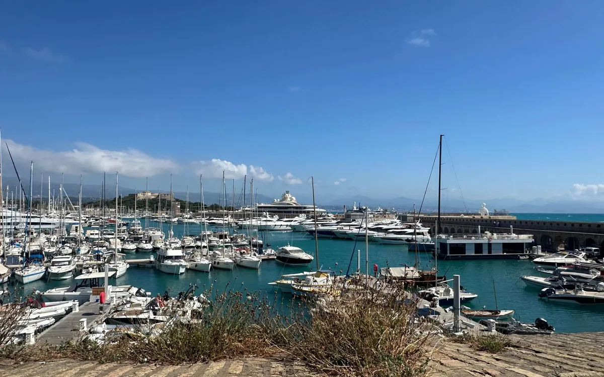 A Riviera marina packed with sailing boats and motor yachts under a blue sky