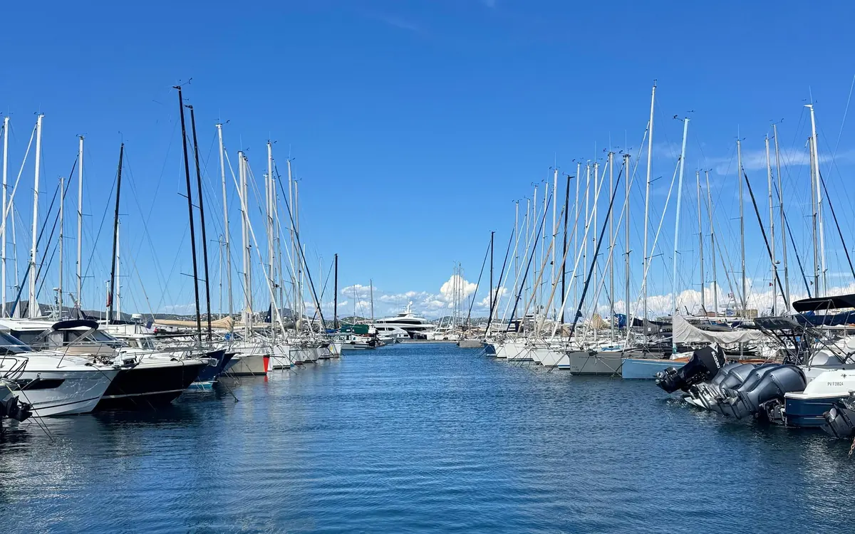 Rows of sailing boats and motorboats moored in the marina at Saint-Tropez under a blue sky