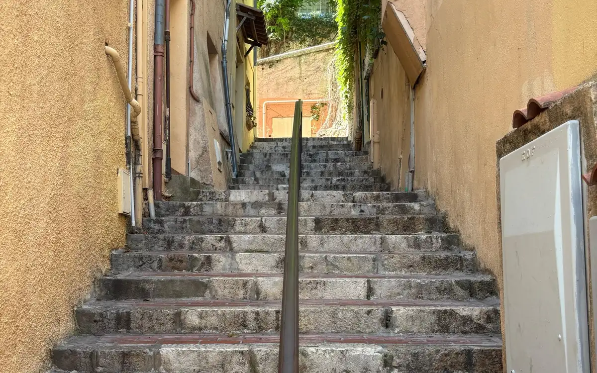 A narrow stepped lane between old houses in Le Suquet